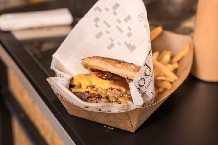 Burger τυλιγμένο σε χαρτί εφημερίδας με πατάτες